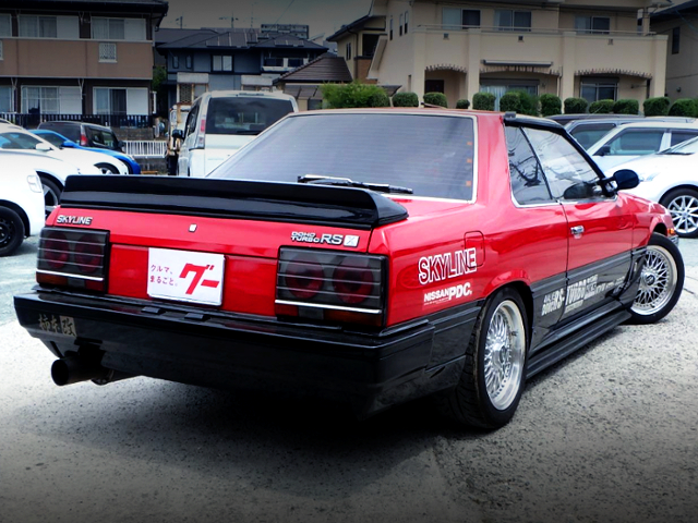 REAR EXTERIOR OF DR30 SKYLINE OF RED AND BLACK TWO-TONE.